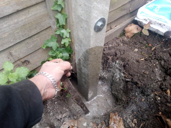 mixing postcrete with water in a post hole